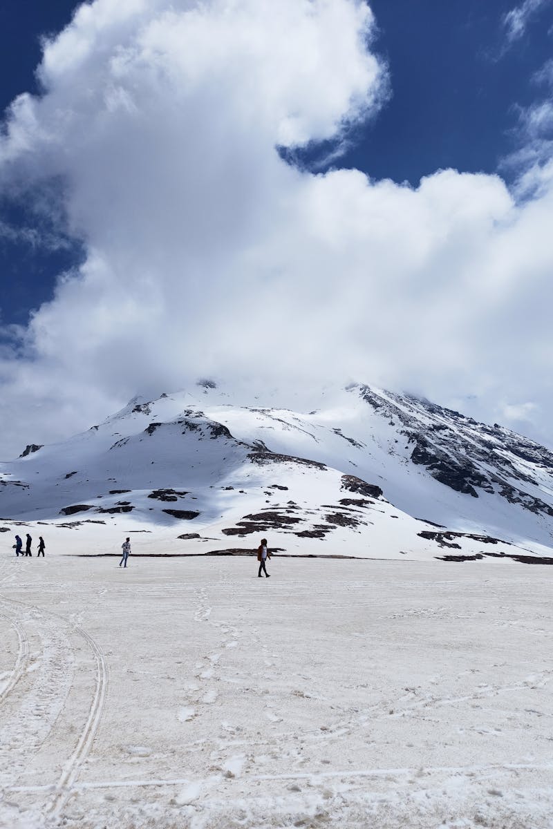 Scenic view of snow-capped peaks under cloudy skies in Rohtang, Himachal Pradesh.