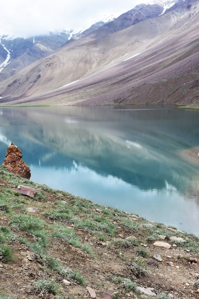 Breathtaking view of a mountain lake with campers enjoying the serene landscape and vibrant tents.